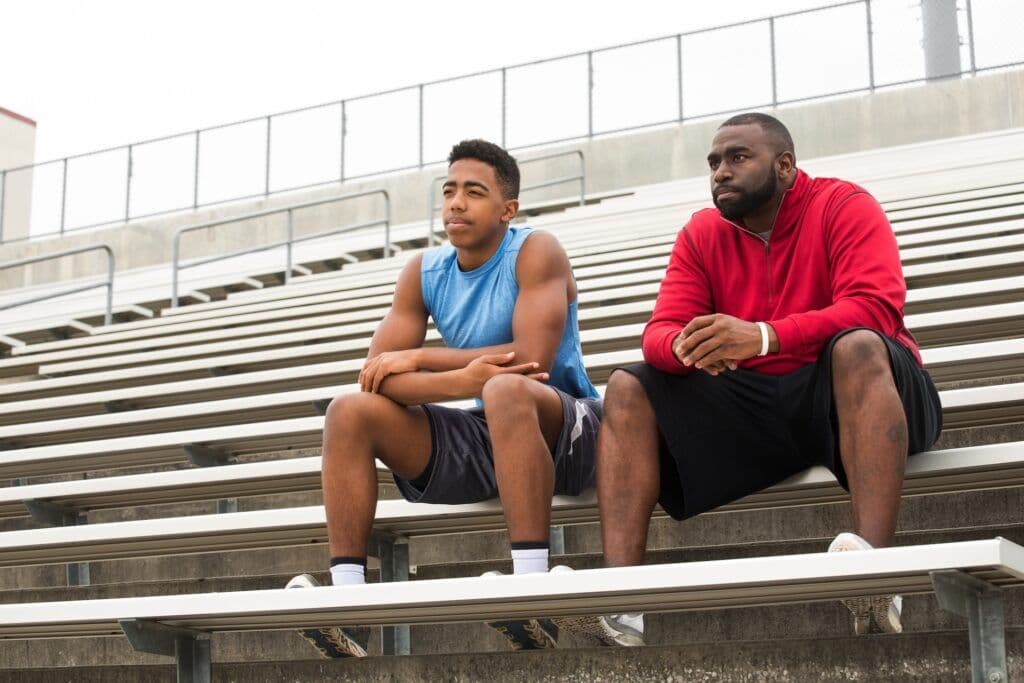 Teen and guardian on bleacher steps